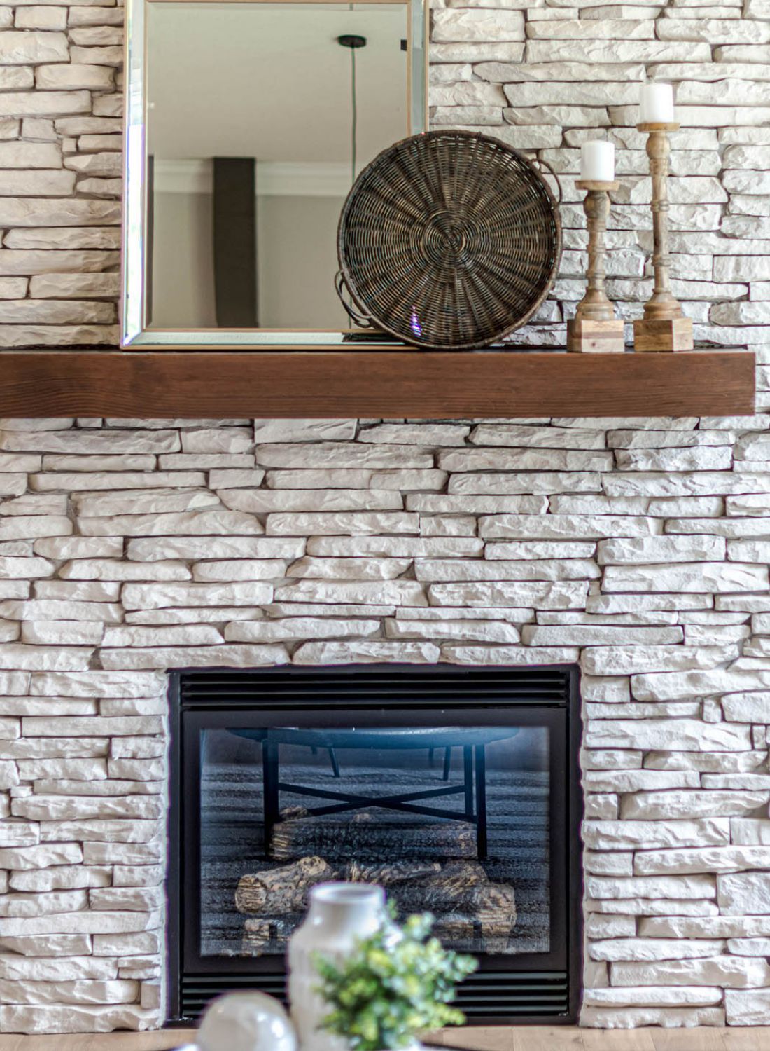 Light stone fireplace with wooden mantle in cozy home